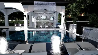 Bubblers and deck jets on the tanning shelf, rain curtain behind, white chaises in the water