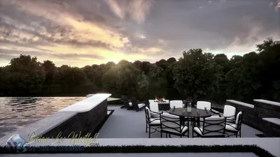 Deck dining with a fire table and white chairs, the lake and treeline behind at sunset