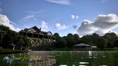 From the water: the lodge on its stone bluff with the covered boathouse at the shoreline, blue sky