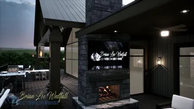 Stone outdoor fireplace with a wall-mounted screen under the covered deck, fan and sconces lit at dusk