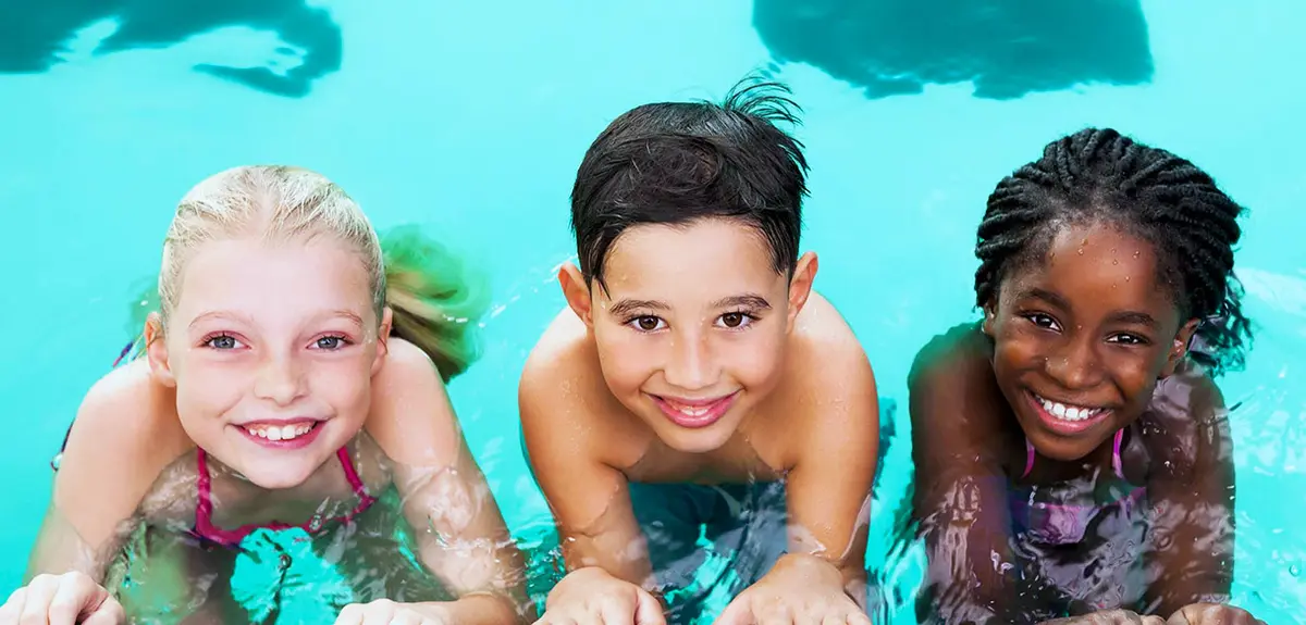 Children smiling at pool edge