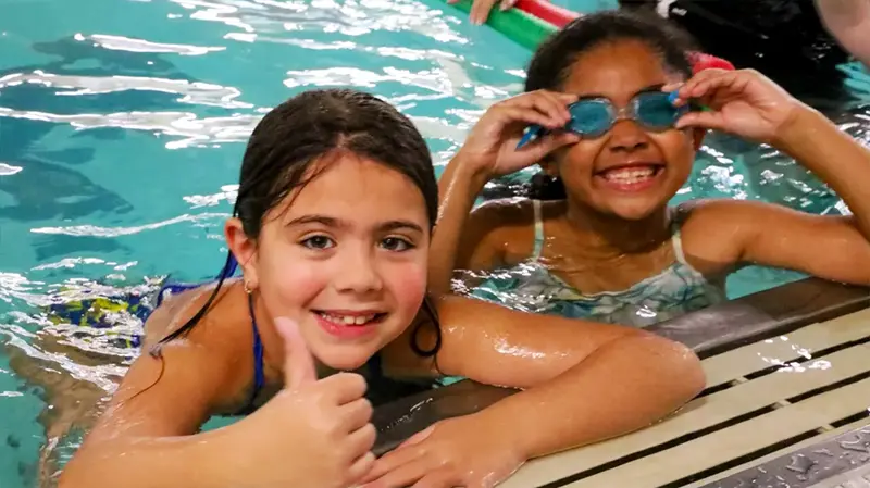 Kids giving thumbs up in pool